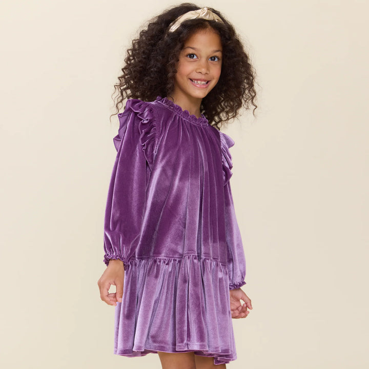 Girl wearing the Girls Harper Dress Lavender Velour with ruffle shoulder details and long sleeves