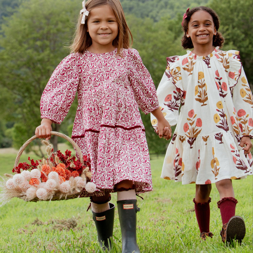 Girl wearing the Girls Harvest Dandelion Dress outdoors with coordinating fall floral style