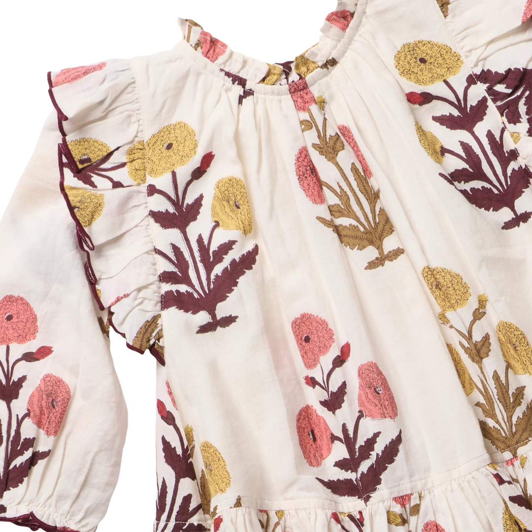 Close-up of Girls Harvest Dandelion Dress with ruffled neckline, shoulder trim and floral print