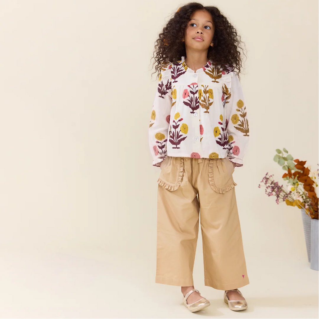 Girl wearing the Girls Harvest Dandelion Top with tan wide-leg pants for a fall outfit