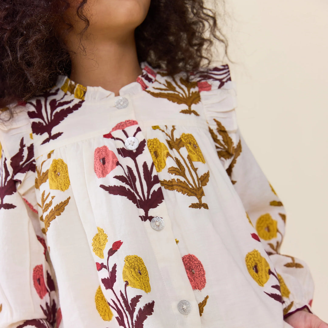 Close-up of Girls Harvest Dandelion Top featuring ruffled trim, floral print and decorative buttons