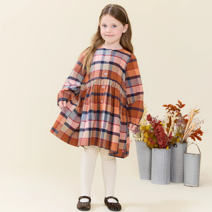 Girl wearing the Girls Hayride Plaid Dress styled with cream tights for fall