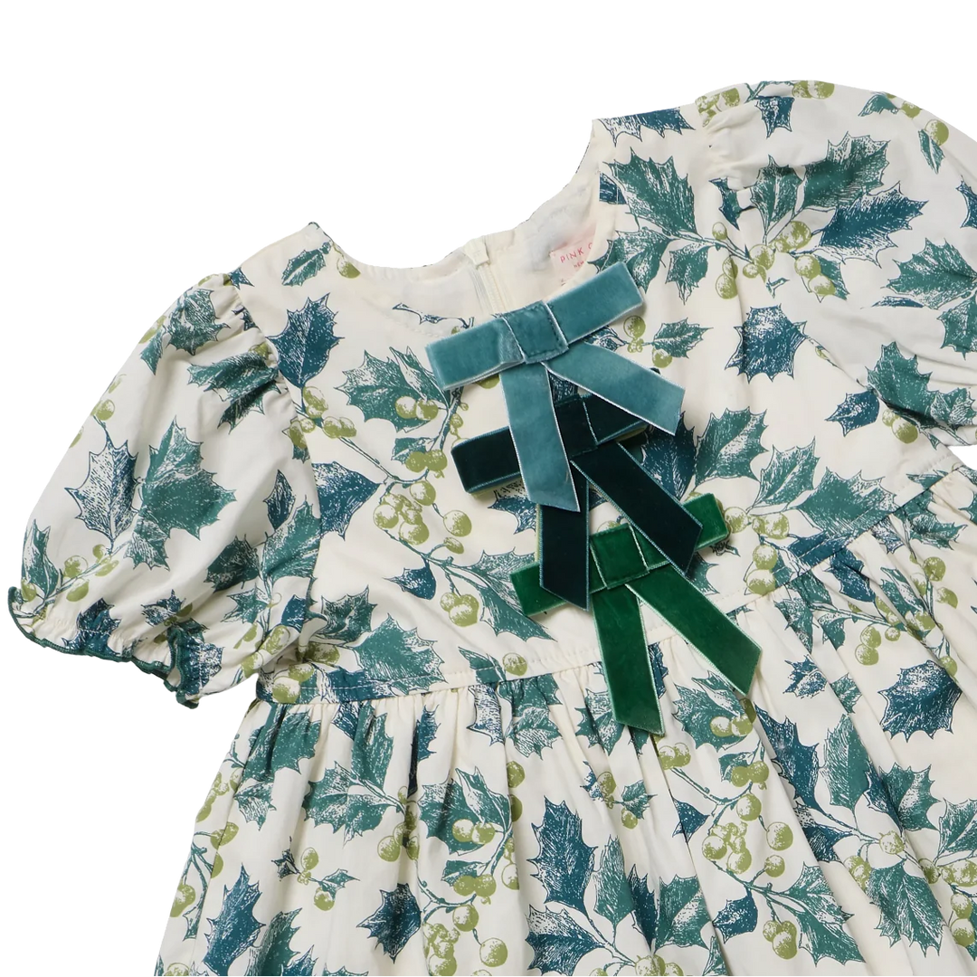 Close-up of Green Holly Hermione Dress with festive holly print and green velvet bows