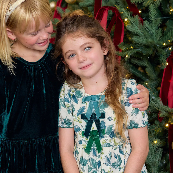 Girl modeling Green Holly Hermione Dress with puff sleeves and velvet bow details