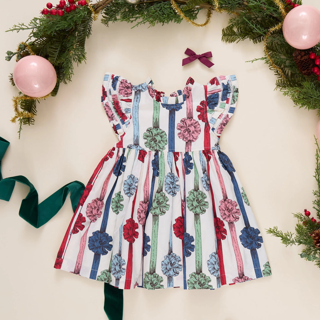 Pink Chicken Girls Present Bows Dress styled with Christmas greenery, ornaments, and festive holiday accessories