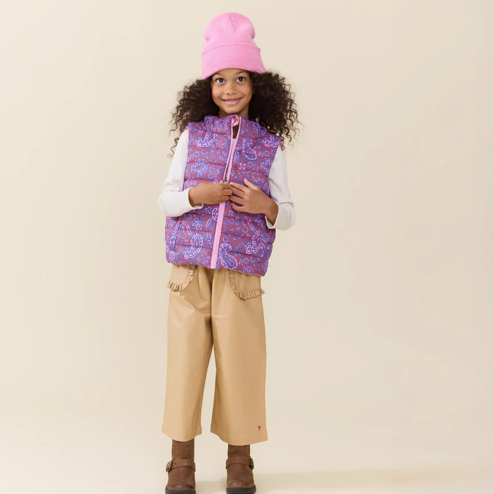 Girl wearing the Reversible Riley Vest Purple Paisley Vines with pink beanie and tan pants