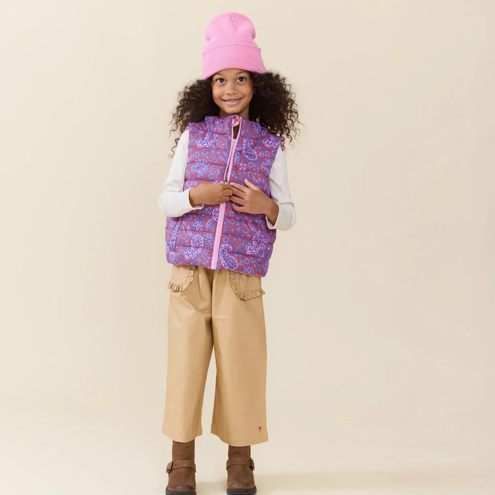Girl wearing the Reversible Riley Vest Purple Paisley Vines with pink beanie and tan pants