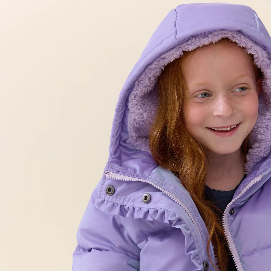 Girl wearing Lavender Ruffle Pete Puffer showing the cozy plush-lined hood and ruffle trim