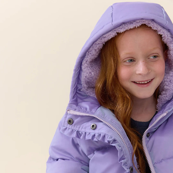Girl wearing Lavender Ruffle Pete Puffer showing the cozy plush-lined hood and ruffle trim