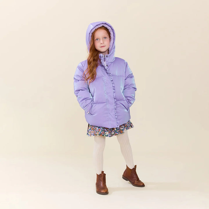 Girl wearing the Lavender Ruffle Pete Puffer hooded jacket with a floral dress and boots