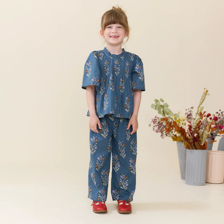Girl modeling Balsam Dewdrop floral Theodore Pants with matching blue floral blouse