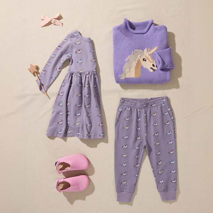Girls unicorn jogger pants styled with a lavender unicorn sweater, matching unicorn dress and pink shoes