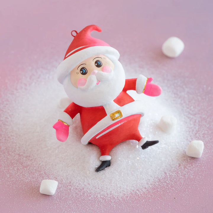 Glitterville Baby Papa Noel ornament featuring a cartoon-style Santa Claus in a bright red suit with white trim, pink mittens, black boots, and hand-painted facial details.