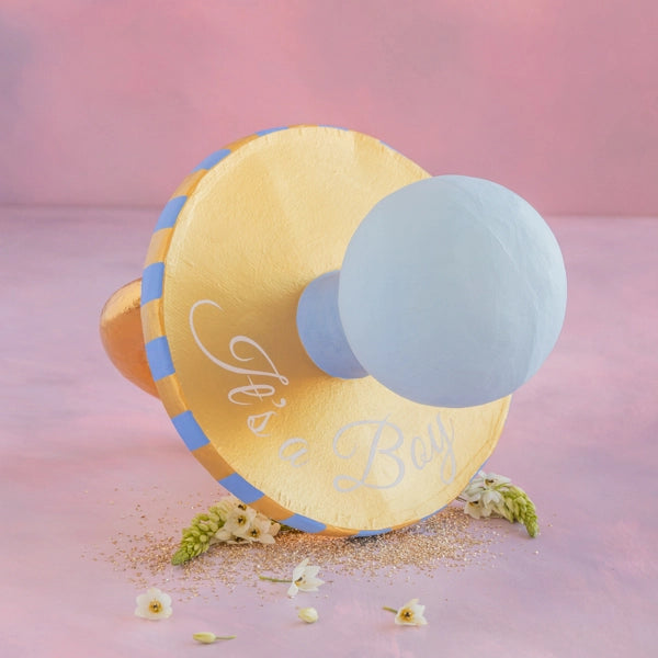 Image of Glitterville's Bluey Binky "Its a Boy" display pictured on it's side against a pink background. 