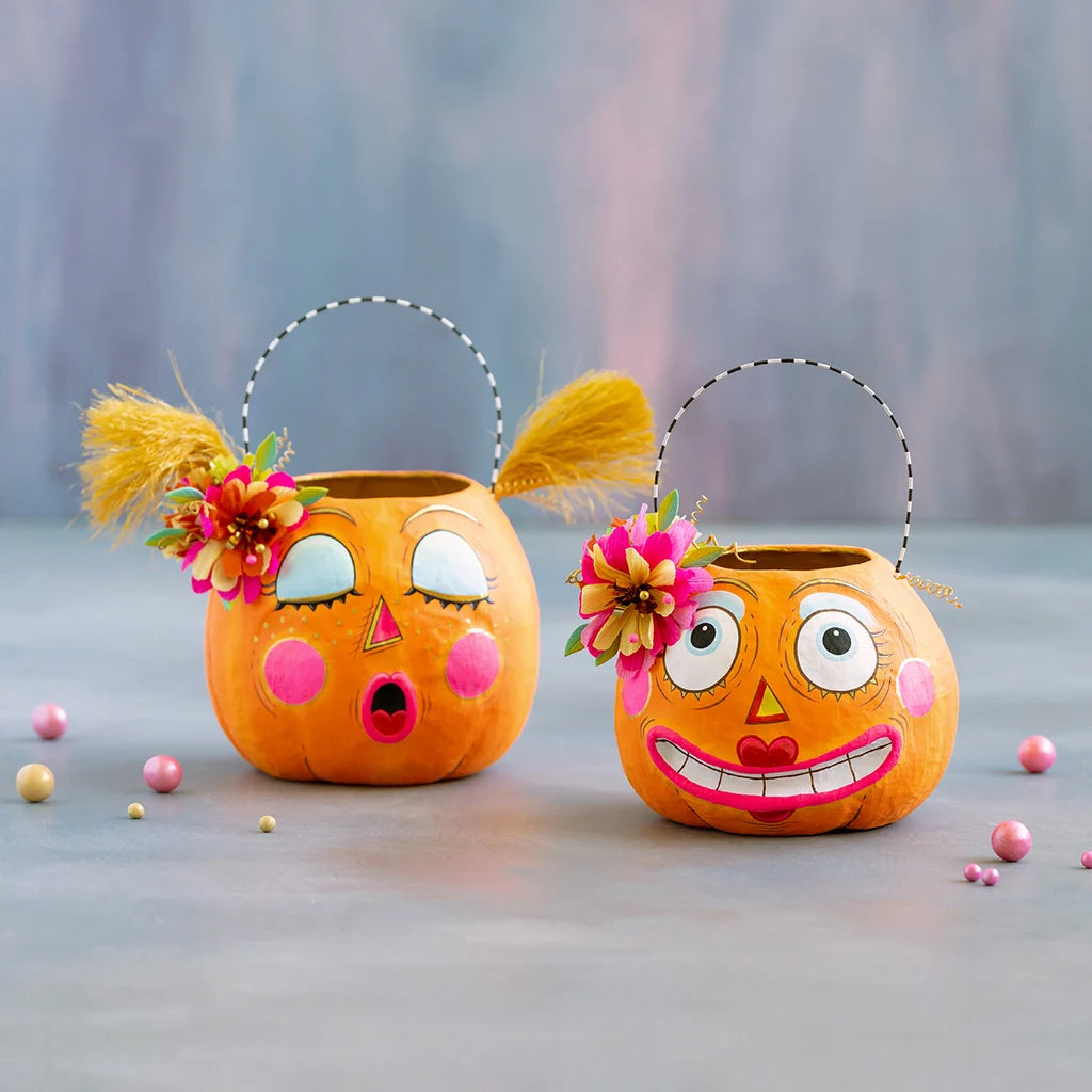Glitterville Bumpkin Betty and Gossip Gourdy pumpkin buckets featuring playful faces, colorful floral accents, and whimsical Halloween details.