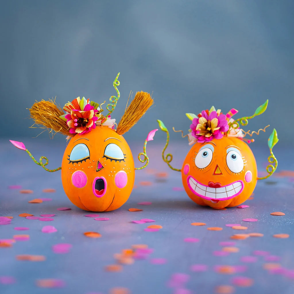Glitterville Bumpkin Betty and Gossip Gourdy pumpkin tabletop edition figurines featuring playful faces, colorful floral accents, and whimsical Halloween details.