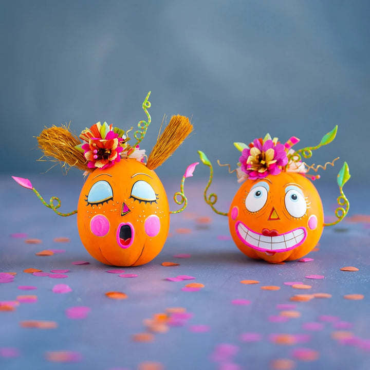Glitterville Bumpkin Betty and Gossip Gourdy pumpkin tabletop edition figurines featuring playful faces, colorful floral accents, and whimsical Halloween details.