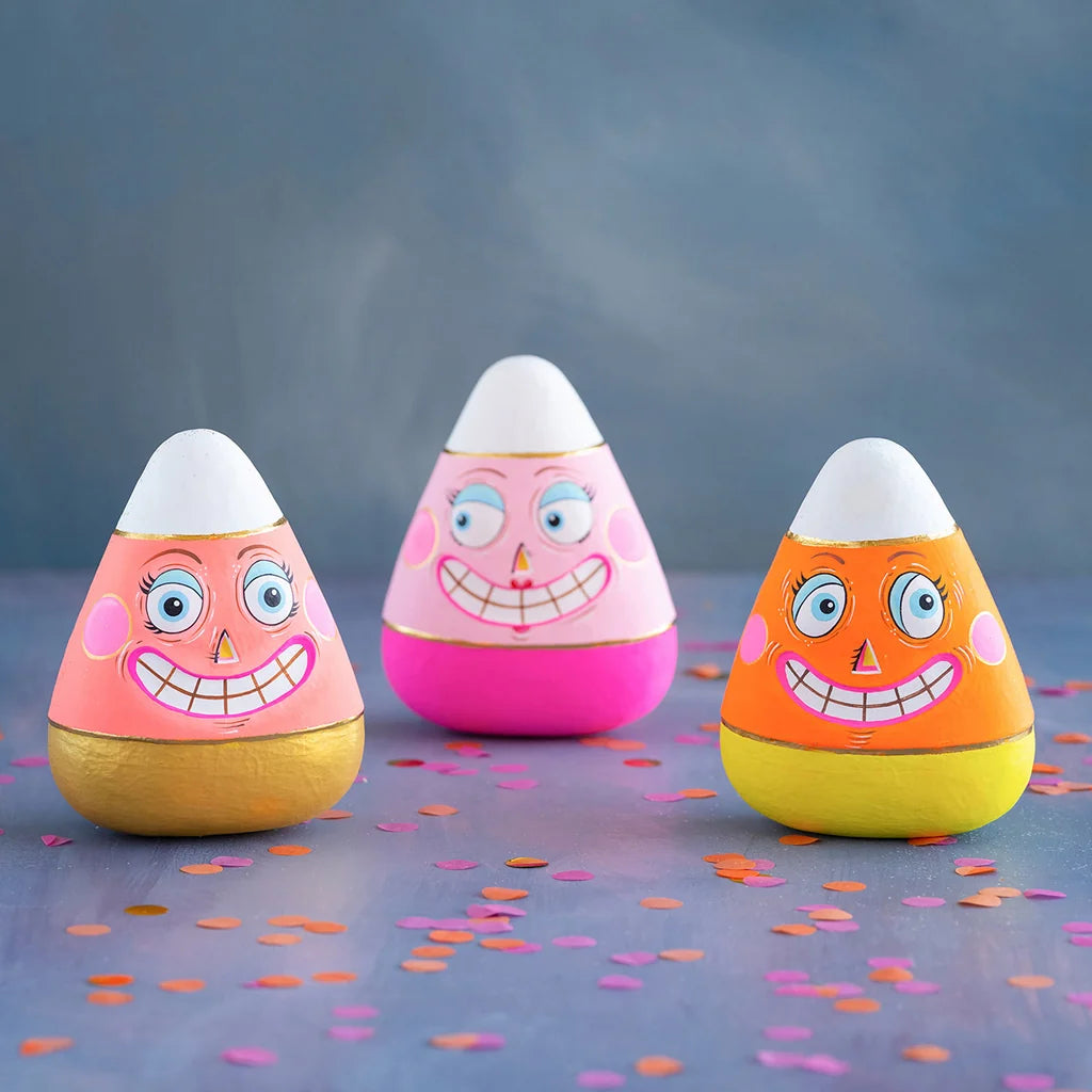 Glitterville Candice, Kettle and Carl candy corn figurines featuring colorful pink, orange, yellow, and white designs with playful smiling faces.