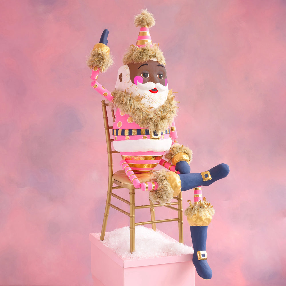 Image of Glitterville's Black Papa Noel Display Figure, dressed in hot pink and gold. 