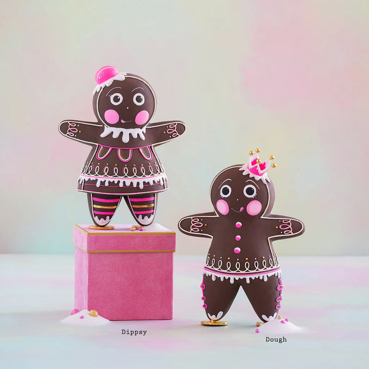 Glitterville Brand Dippsy and Dough brown gingerbread figures displayed together with pink and white icing details, gold accents, and their names labeled beneath each figure.