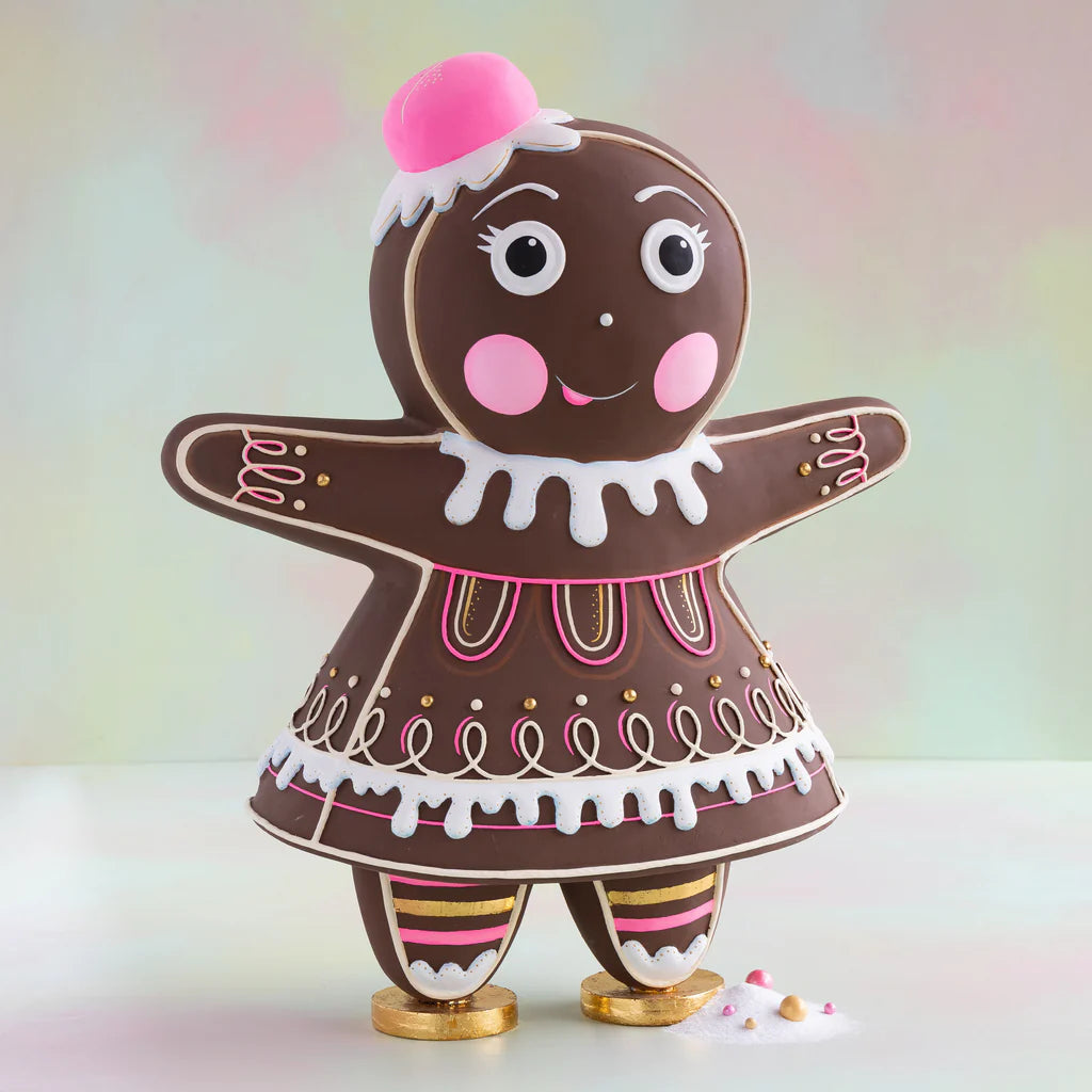 Glitterville Dippsy gingerbread figure with a brown gingerbread body, pink and white icing details, pink hat, striped legs, and gold shoes.