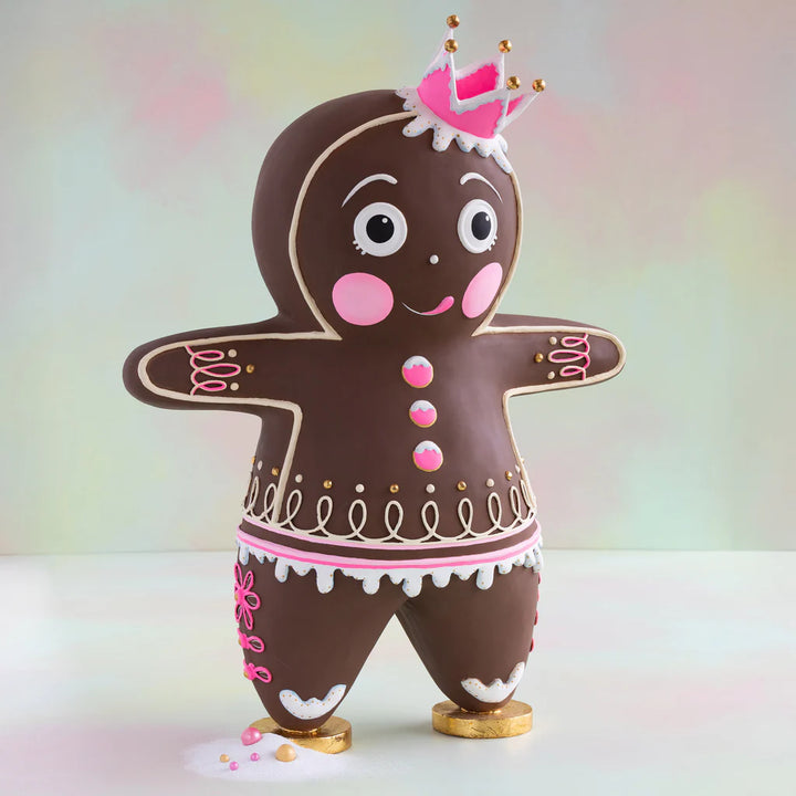 Glitterville Dough gingerbread figure with a brown body, pink and white icing details, pink crown, decorative buttons, swirled icing, and gold shoes.