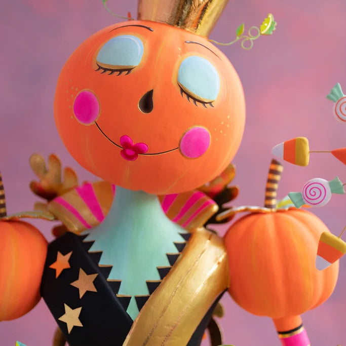Glitterville Fairy Gourdmother large display close-up featuring a pumpkin face with blue eyes, pink cheeks, gold crown, striped bodice, pumpkins, and candy-inspired details.