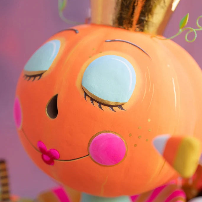 Glitterville Fairy Gourdmother large display face detail featuring a pumpkin face with closed blue eyes, pink cheeks, gold crown, and candy-inspired accents.