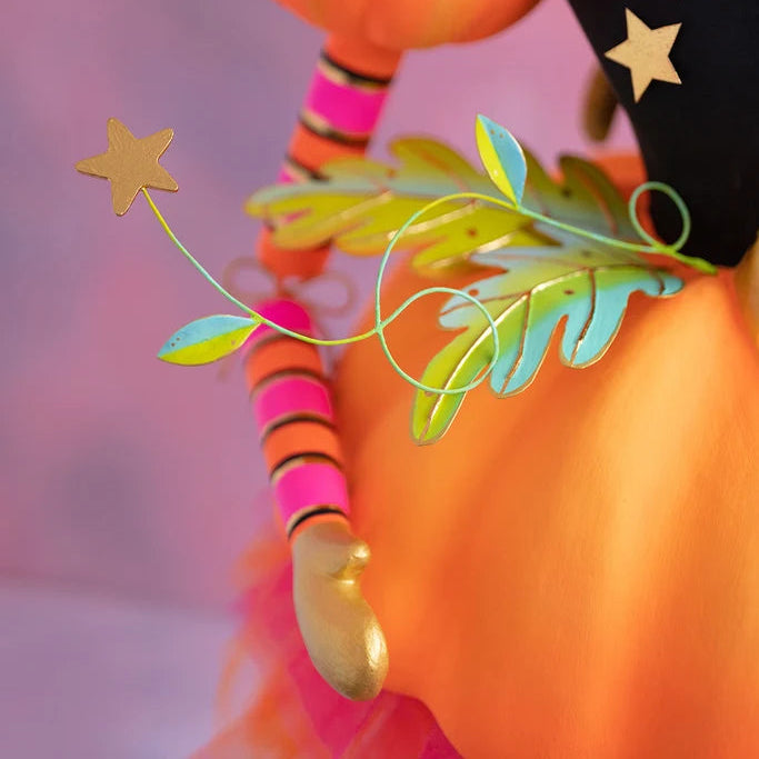 Glitterville Fairy Gourdmother large display close-up showing the orange pumpkin skirt, colorful leafy floral accents, gold star detail, striped pink and orange arm, and gold hand.