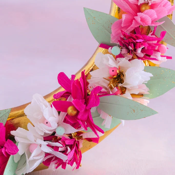 Glitterville Gallop's Lucky Horseshoe floral detail featuring pink and white flowers, mint green leaves, and gold accents on a gold horseshoe.