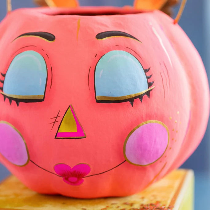 Glitterville Gurdie Pumpkin Pixie Bucket in coral pink with light blue eyes, pink cheeks, gold accents, and an open top with a wire handle.