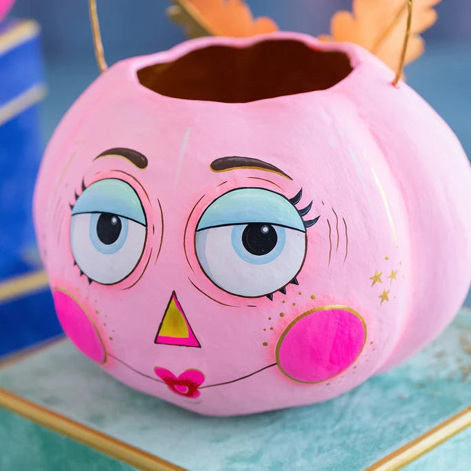 Glitterville LaSquasha Pumpkin Pixie Bucket in light pink with large blue eyes, pink cheeks, gold star details, and an open top with a wire handle.