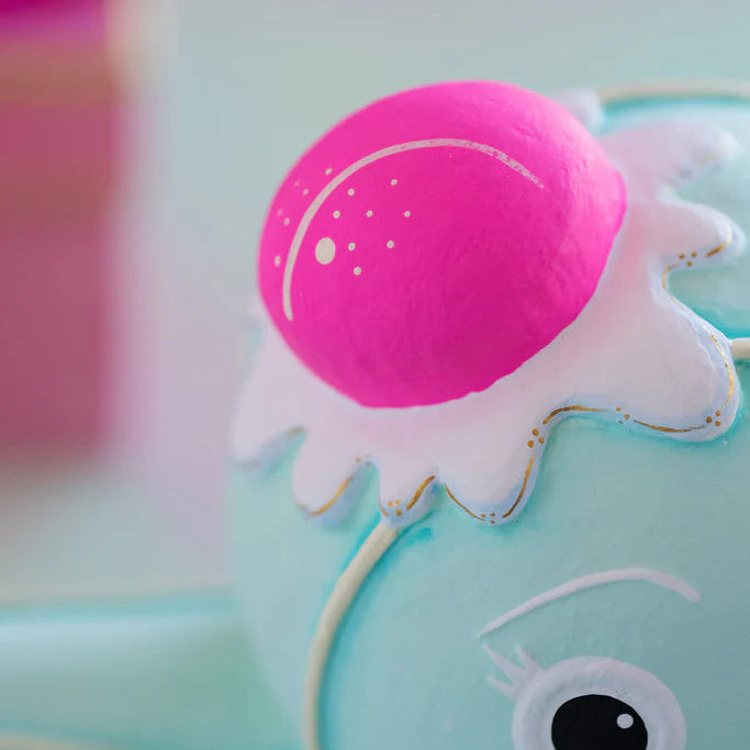 Close-up of the Glitterville Mint Dippsy gingerbread figure featuring a bright pink gumdrop hat with delicate white icing details and gold accents, highlighting the whimsical handcrafted decoration and pastel Christmas design.