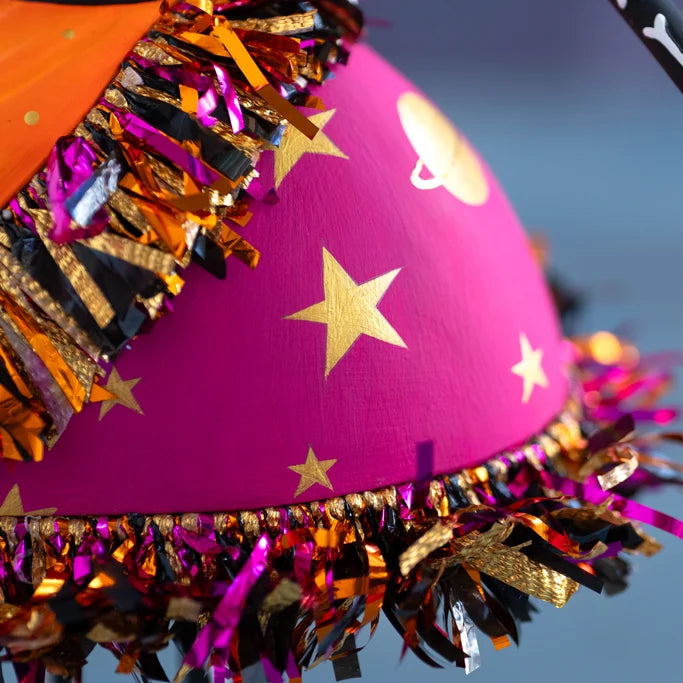 Glitterville Nelly Skelly Fortune Telly close-up showcasing the hot pink skirt with hand-painted gold stars and colorful metallic fringe trim.