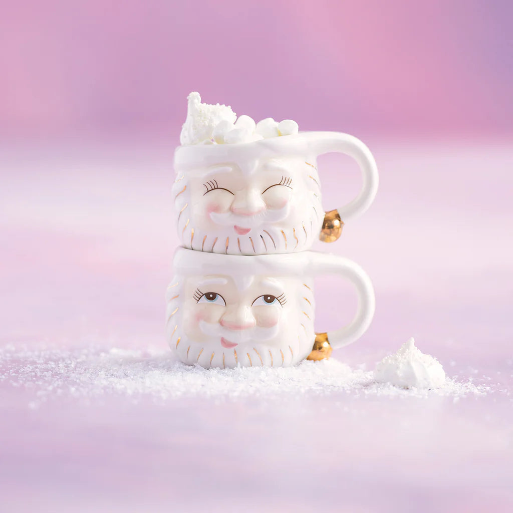 Glitterville Papa Noel ceramic Santa mug set featuring two white Santa face mugs stacked together, with gold detailing and festive marshmallow accents.