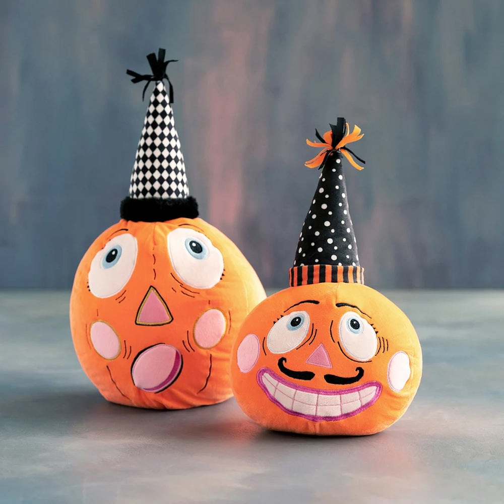 Glitterville Party Pumpkins featuring two whimsical orange pumpkin plushes, one with a mustache and both wearing black-and-white party hats. 