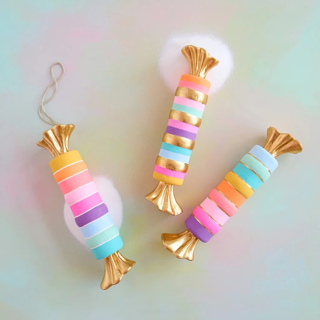 Glitterville pastel Rainbow Taffy display set featuring three whimsical oversized wrapped candies in colorful pink, purple, blue, yellow, and mint stripes with shimmering metallic gold wrappers and accents.