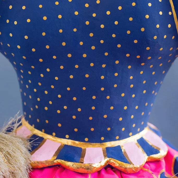 Close-up detail of Glitterville Pinky Itchy Witchy showing her hourglass waist. The navy dress with gold polka dots is complete with a striped scalloped edge for even more dimension.
