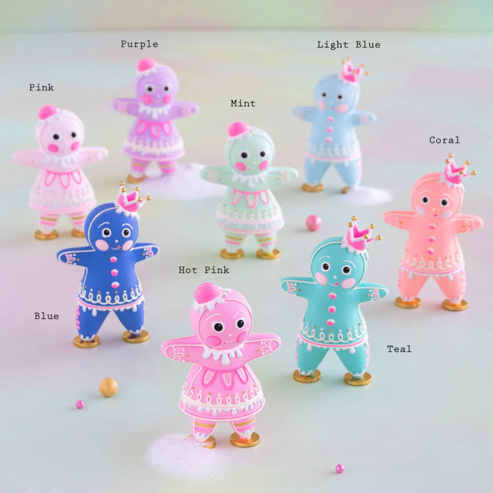 Glitterville rainbow Dippsey and Dough gingerbread figures displayed together in eight pastel colors, with each figure labeled by color: Pink, Purple, Mint, Light Blue, Coral, Blue, Hot Pink, and Teal. The colorful gingerbread figures feature detailed white and pink icing, decorative buttons, striped accents, gold shoes, pink gumdrop hats, and crowns in a whimsical pastel Christmas holiday display.