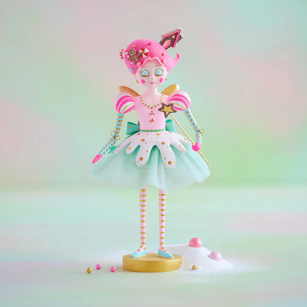 Tabletop Glitterville Sugar Plum Fairy display figure standing on a round gold base, featuring a pastel pink candy-inspired outfit, white and mint tulle skirt, striped sleeves and legs, pink candy-adorned hair, gold accents, and a star-tipped wand.