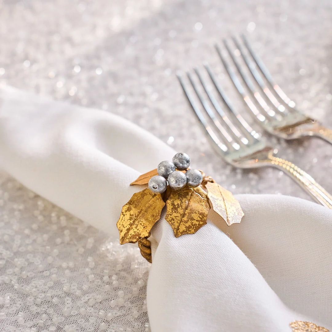 Close-up of Gold Holly Napkin Ring with textured metallic gold leaves and clustered silver berries