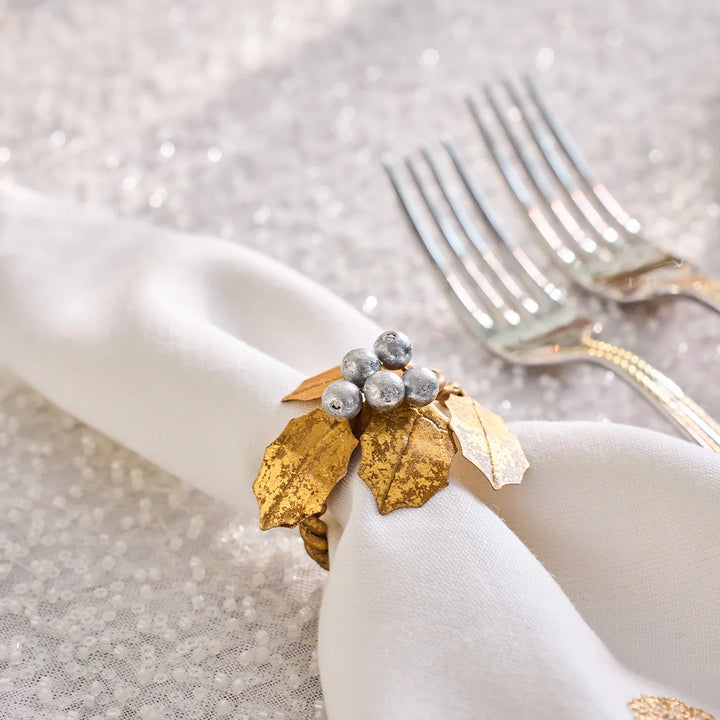 Close-up of Gold Holly Napkin Ring with textured metallic gold leaves and clustered silver berries