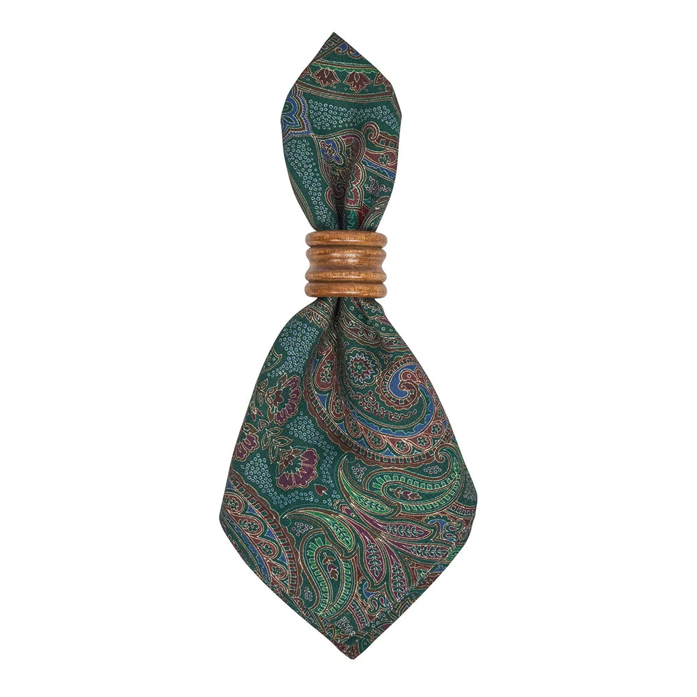 Green paisley cloth napkin folded in a decorative wooden napkin ring, showing the detailed multicolor paisley pattern.