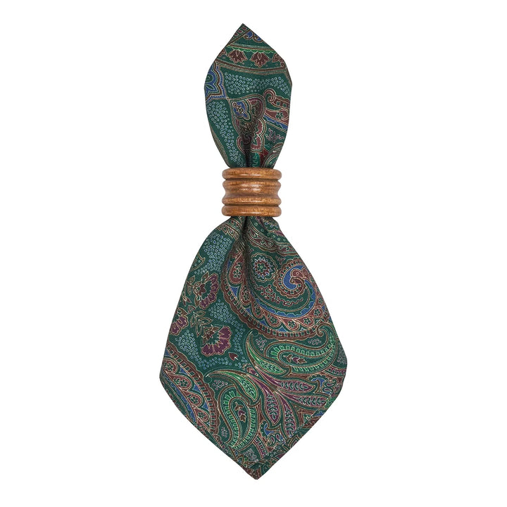 Green paisley cloth napkin folded in a decorative wooden napkin ring, showing the detailed multicolor paisley pattern.