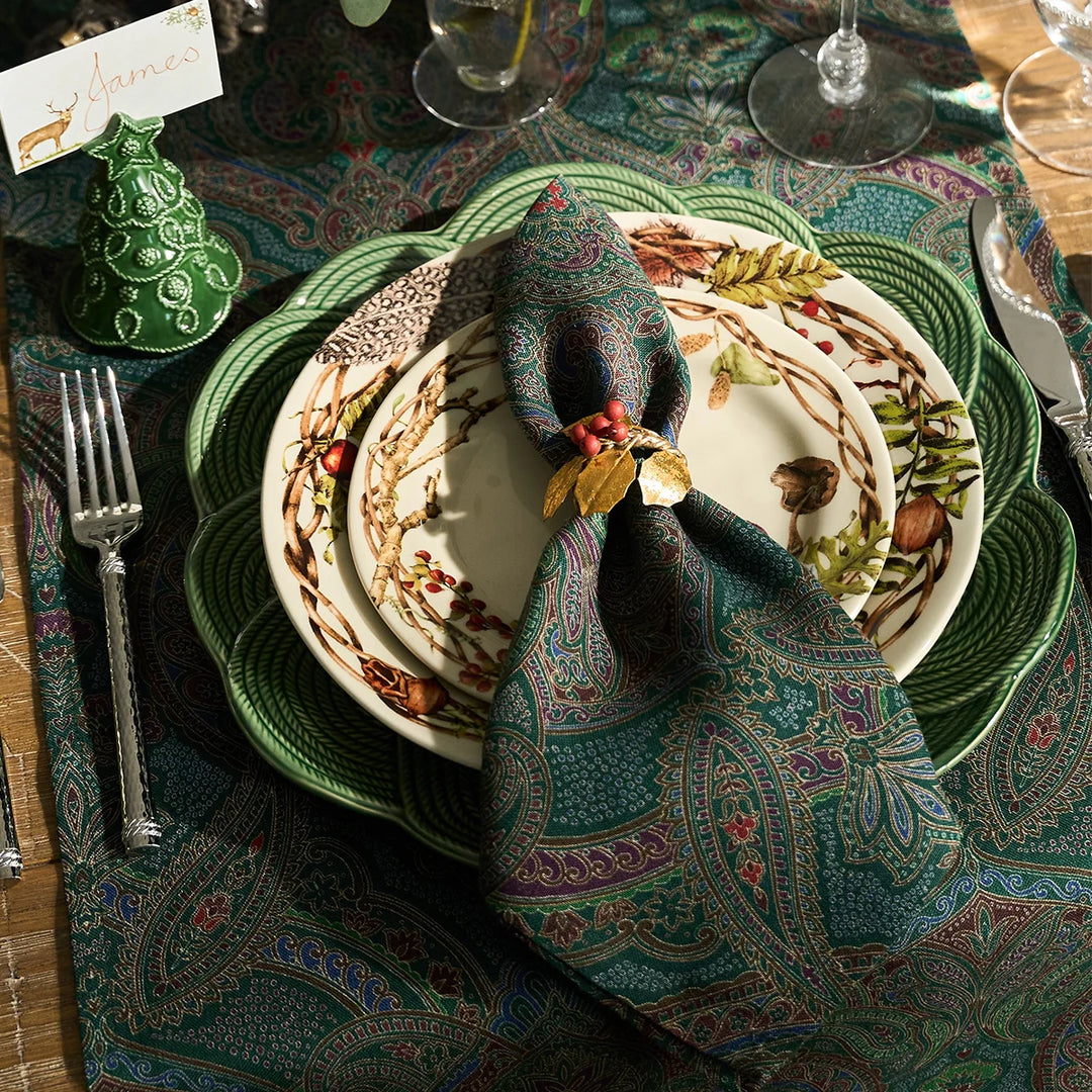 Green paisley table runner styled with coordinating paisley napkin, green dinnerware and botanical plates for an elegant holiday tablescape.