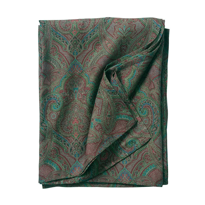 Folded green paisley tablecloth featuring an intricate multicolor pattern with burgundy, blue, brown and botanical-inspired details.