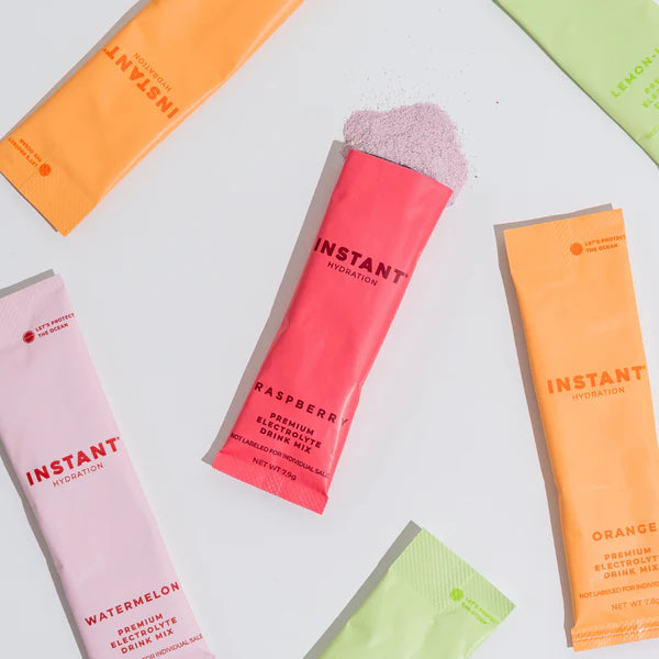 Instant Hydration electrolyte drink mix packets featuring Raspberry, Watermelon, Lemon-Lime and Orange flavors with colorful individual stick packaging.