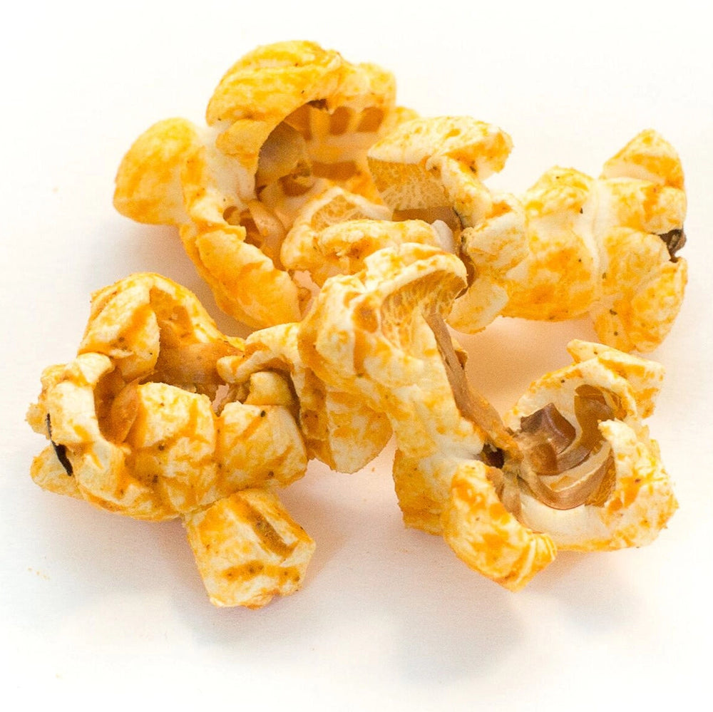 Close-up of Jalapeño Cheddar Hand-Crafted Popcorn coated in cheddar and spicy jalapeño seasoning.