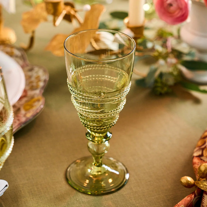 Juliska Amalia green footed goblet featuring signature wrapped glass thread detailing, styled on an elegant tablescape.