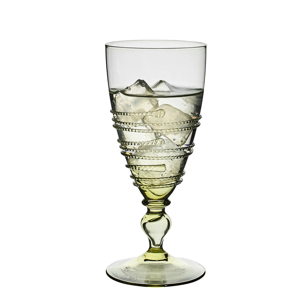 Juliska Amalia green footed goblet filled with ice, featuring pale green glass, a decorative stem and signature wrapped thread detailing.